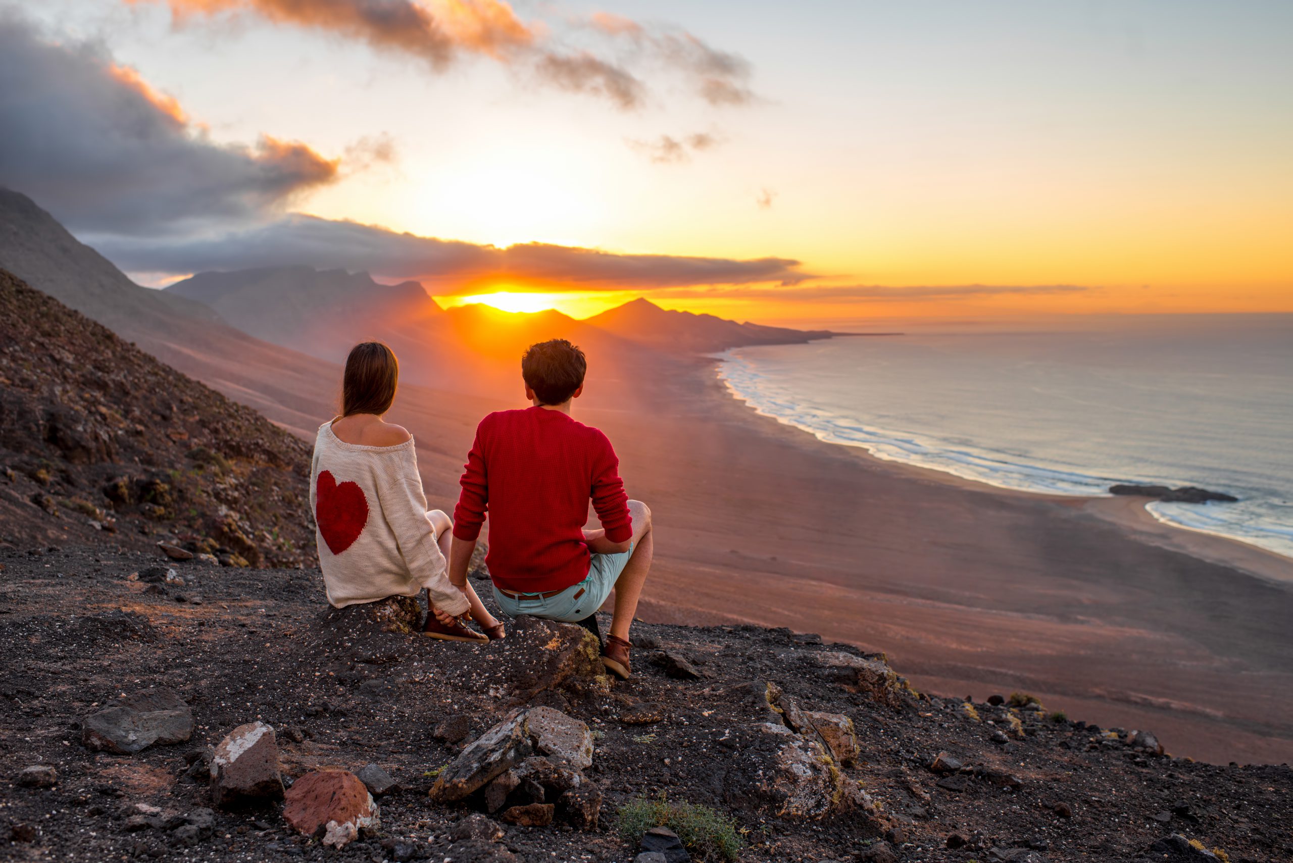 Młoda para ciesząca się pięknym zachodem słońca na wyspie Fuerteventura, licencja: shutterstock/By RossHelen