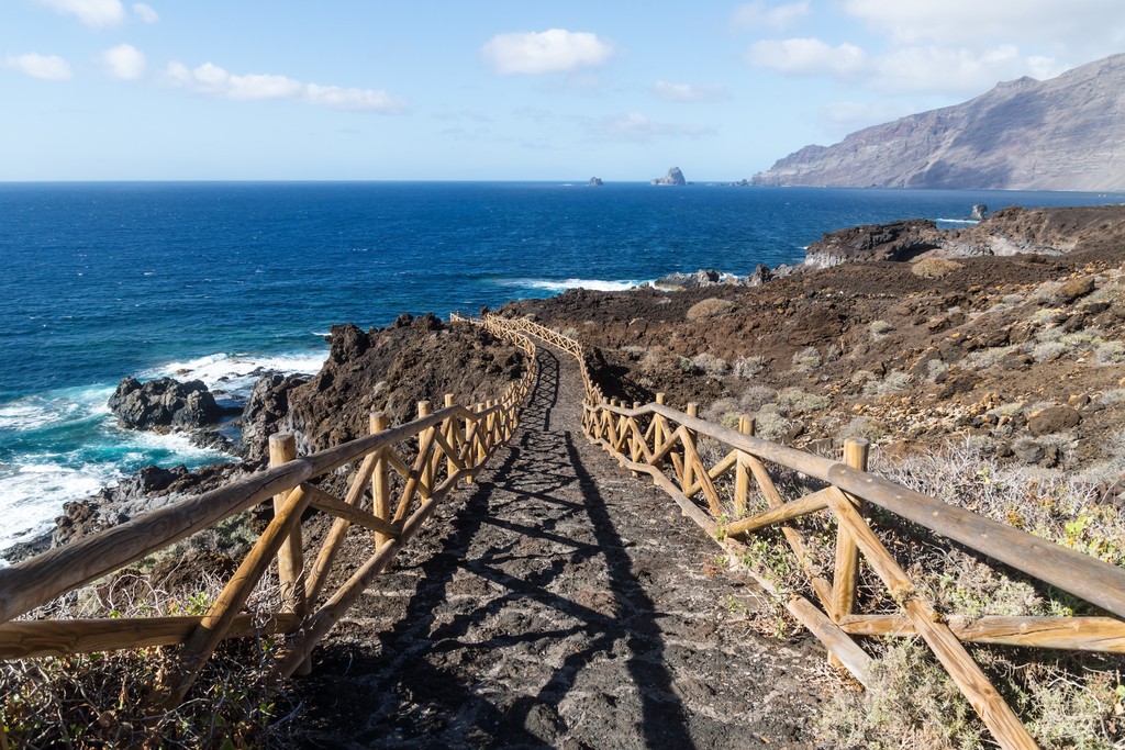 Pathway n black lava rocks to natural pool Charco de los Sargos, El Golfo, El Hierro, Canary Islands, Spain