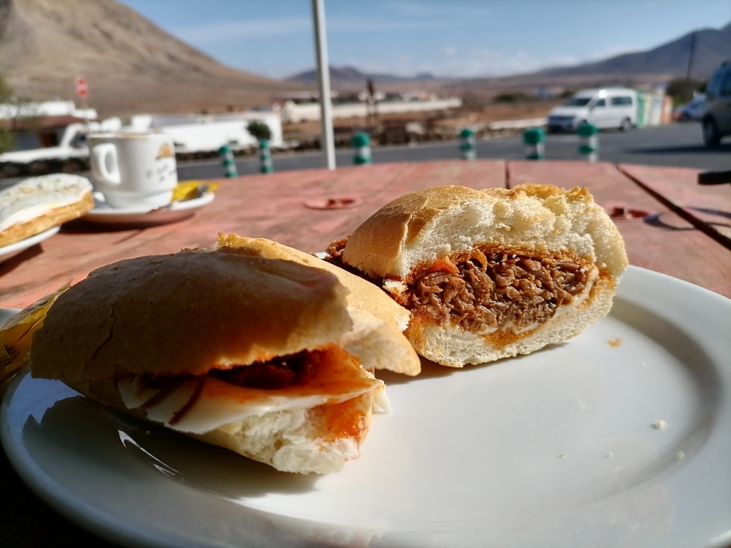 Tindaya, Spain – October 8, 2020: Meatloaf sandwich and coffee with milk as a breakfast in the inner part of Fuerteventura Island.
