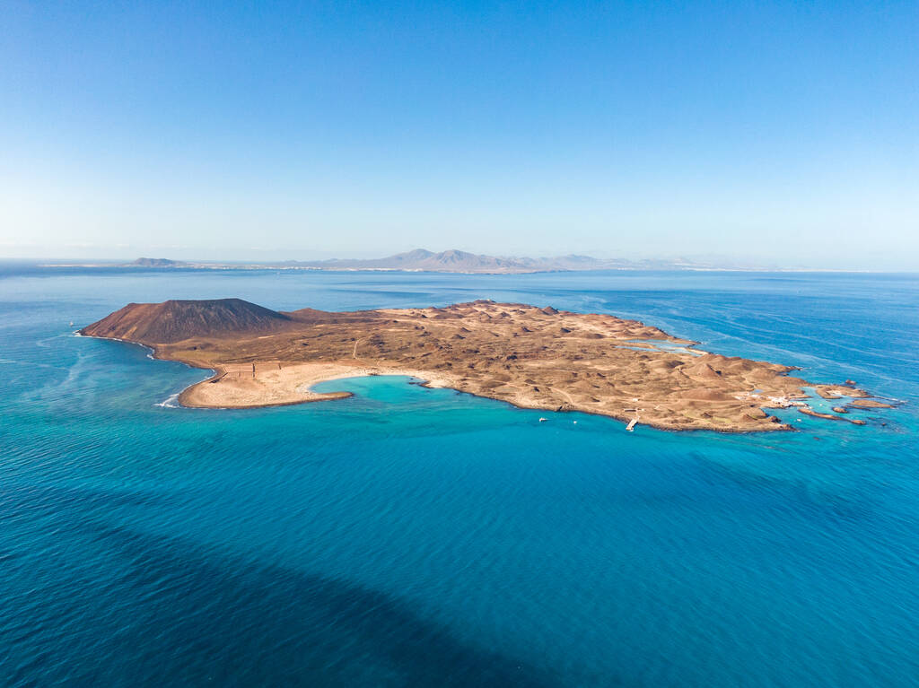 Stunning high angle panoramic aerial drone view of Isla de Lobos, a small uninhabited island just 2 kilometres off the coast of Fuerteventura, Canary Islands, Spain. Lanzarote in the background.