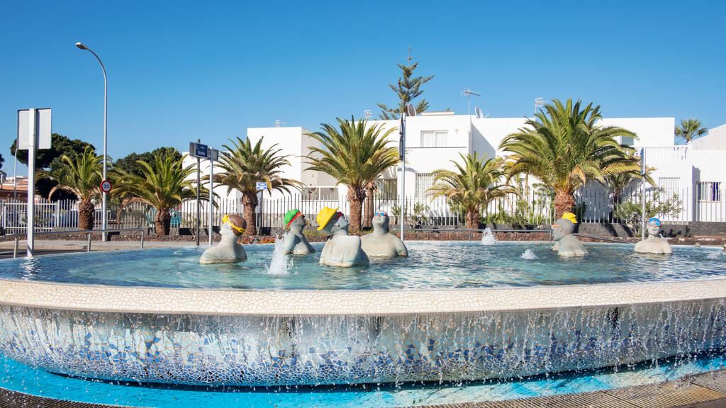 Costa del Silencio, Tenerife, Canary Islands, Spain - December 17, 2019: fountain with tourists in a swimming pool, situated on the corner of the main road Avenida Jose Antonio Tavio and Calle Diana