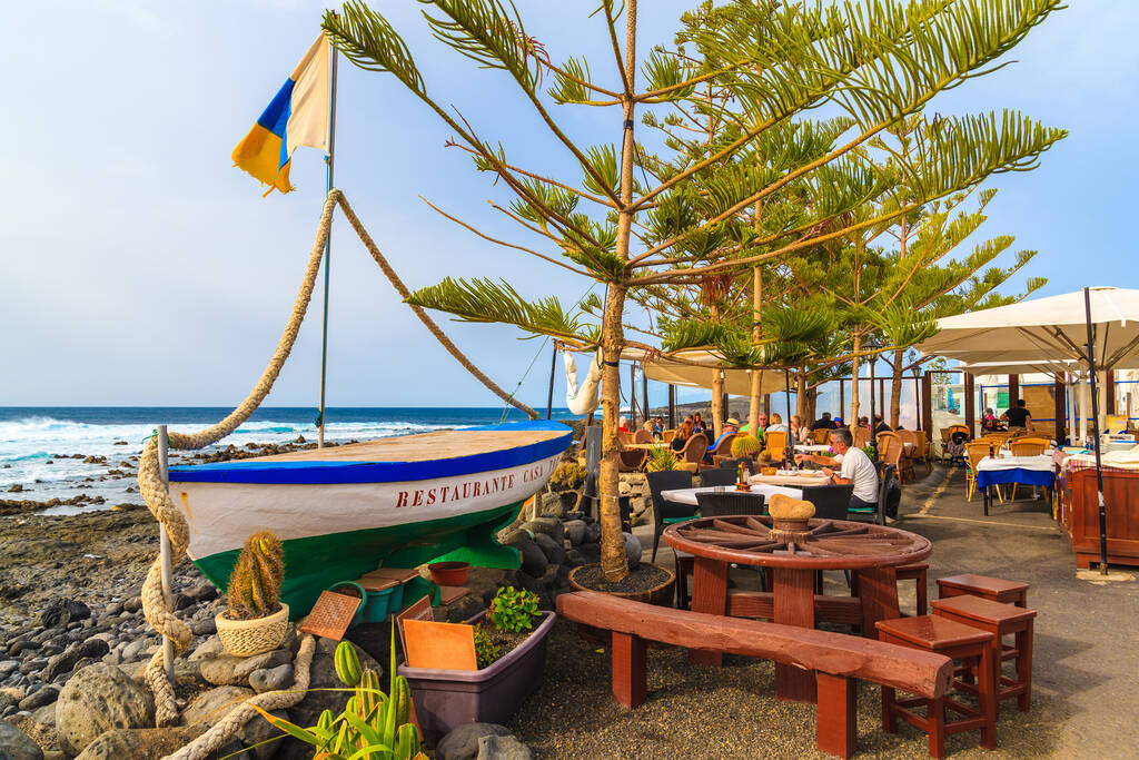 EL GOLFO, LANZAROTE ISLAND - JAN 12, 2015: fishing boat in typical restaurant on coast of Lanzarote island in El Golfo fishing village. Canary Islands are popular holiday destination.