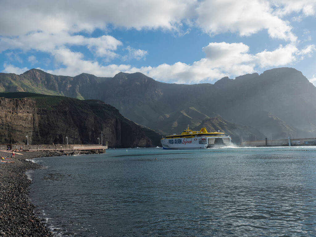 Puerto de las Nieves, Agaete, Gran Canaria, Canary Islands, Spain December 17, 2020: Ferry boat Fred Olsen leaving port with mountains background at Puerto de las Nieves, traditional fishing village