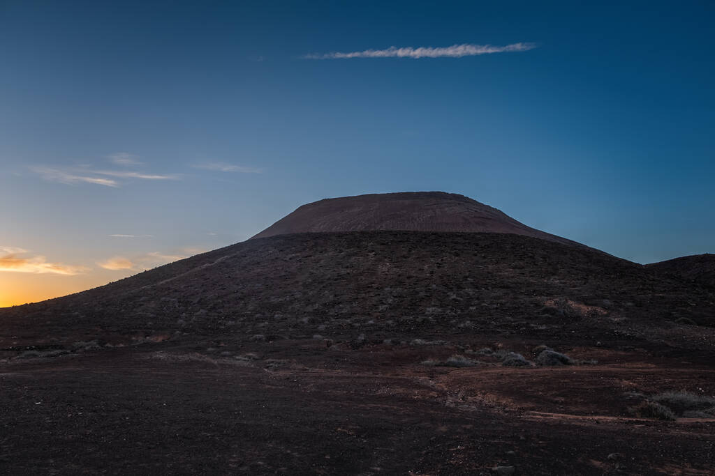 Sunset over mountain Roja and the sand dunes at Corralejo, Fuerteventura, Canary islands. October 2019
