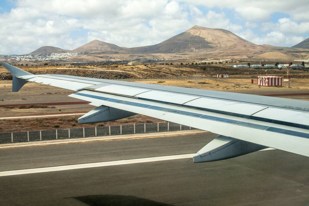 takeoff at airport of Lanzarote with volcanoes at the horizon