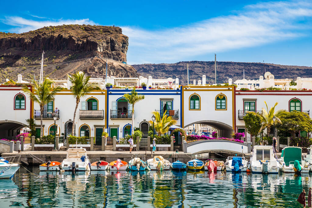 Tradycyjne kolorowe budynki z łodziami z przodu i góry w tle - Puerto de Mogan, Gran Canaria, Wyspy Kanaryjskie, Hiszpania
