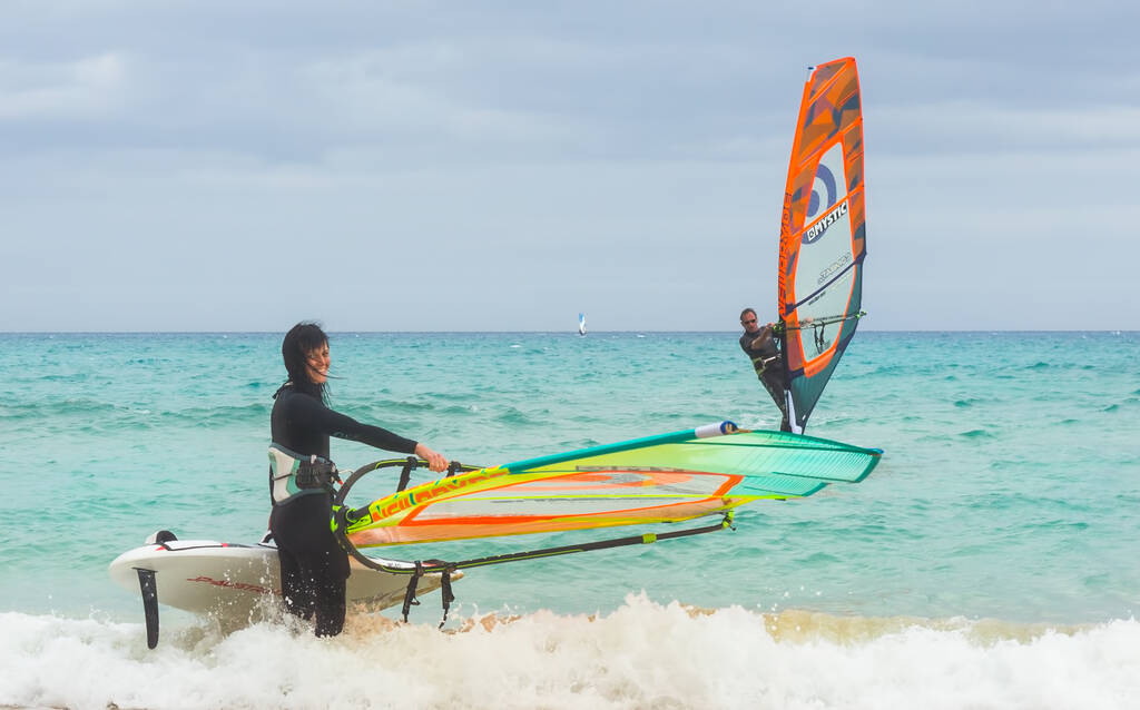 COSTA CALMA, FUERTEVENTURA - FEBRUARY 14, 2016: People windsurfing in Atlantic ocean at windy day. Spain, Canarian island. Rene Egli windsurfing and kitesurfing center.