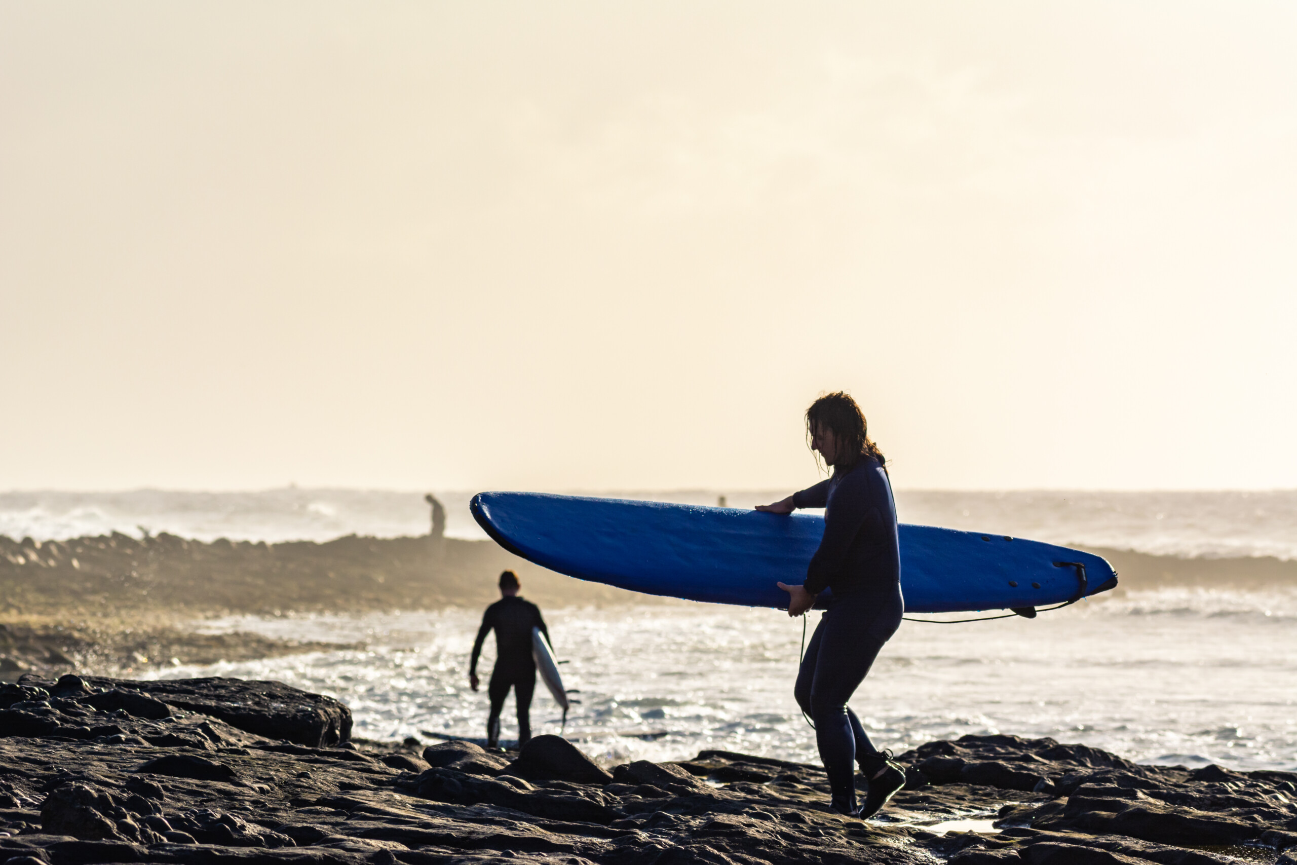 Fale na plaży na Teneryfie o zachodzie słońca. Sylwetka surfera z wody. Miejsce do surfowania wieczorem, licencja: shutterstock/By Elina+Litovkina