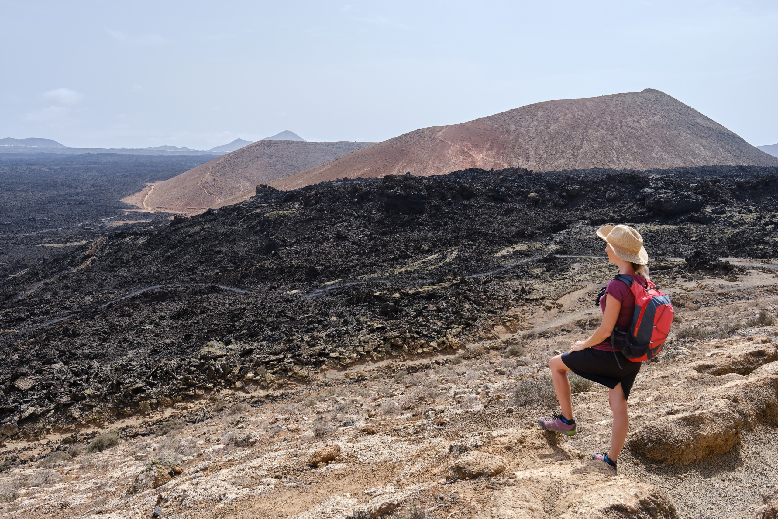 Kobieta uprawia trekking na skalistej wyspie Lanzarote, Wyspy Kanaryjskie, licencja: shutterstock/By Robert-JM